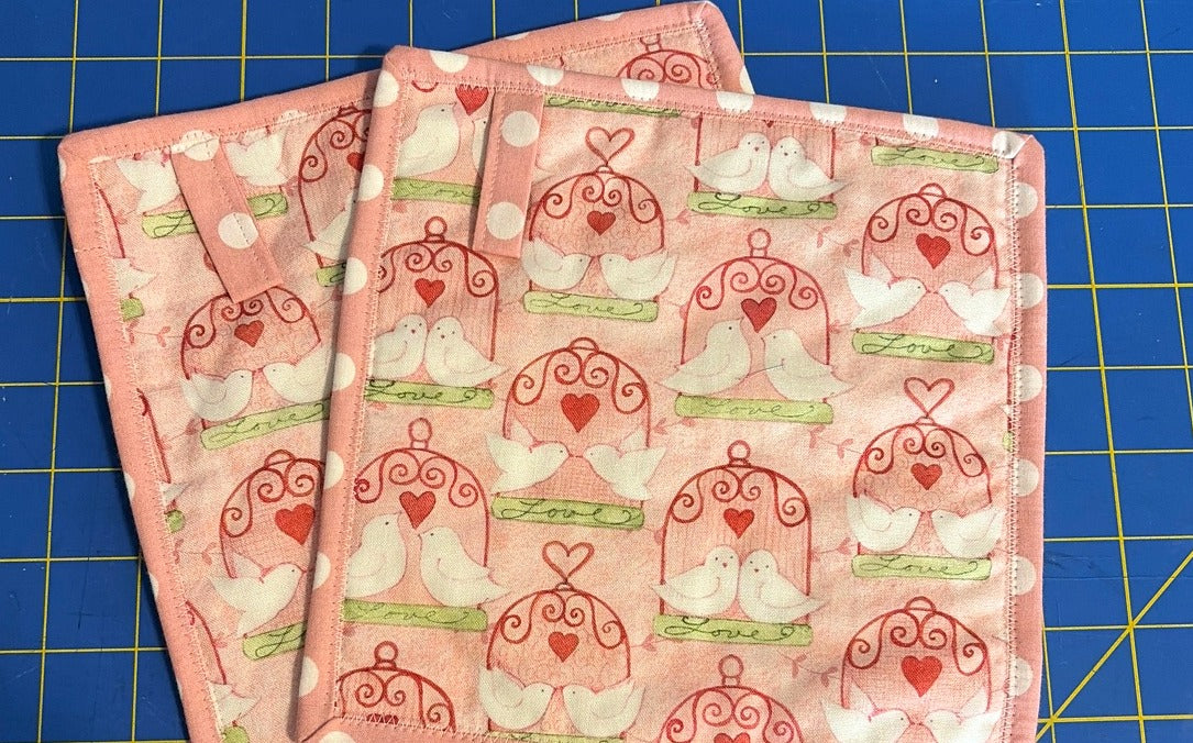 Pink Lovebirds quilted cotton potholders, set of 2, front